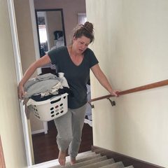 Femme montant l'escalier avec un panier de linge