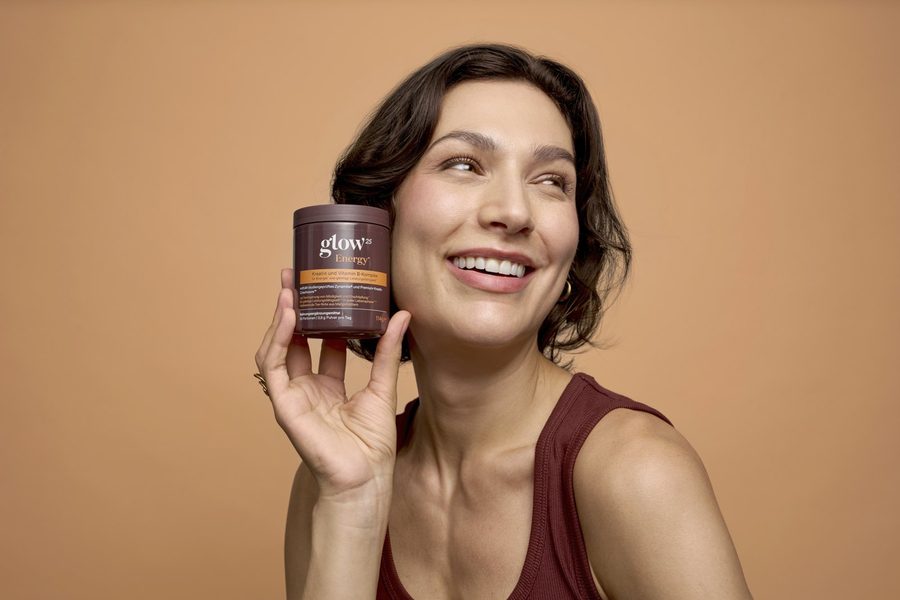 Lächelnde Frau mit der Glow25 Energy Dose