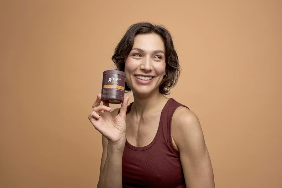 Femme souriante avec le pot Glow25 Energy