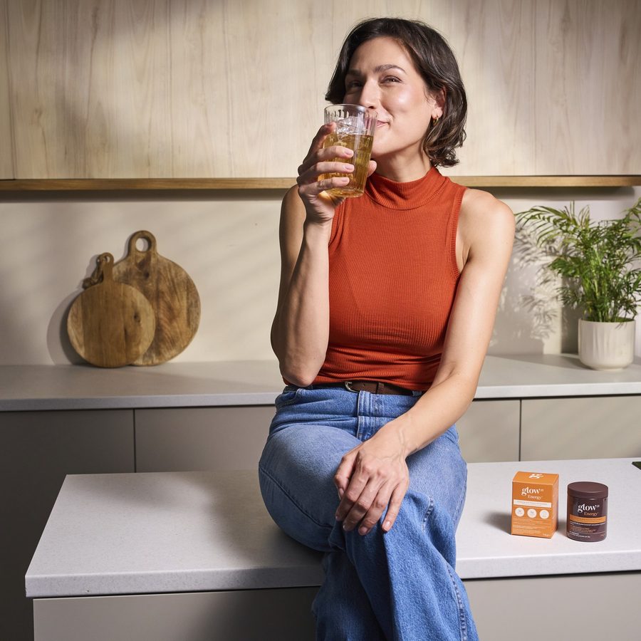 Femme buvant le matin son verre d'Energy dans la cuisine