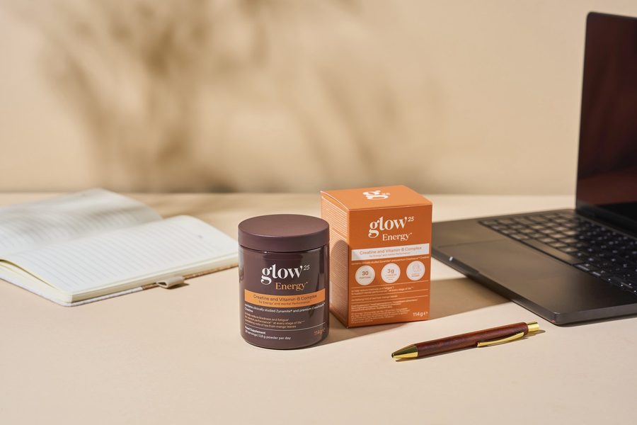 Glow25 Energy à côté d'un carnet et d'un ordinateur portable sur le bureau