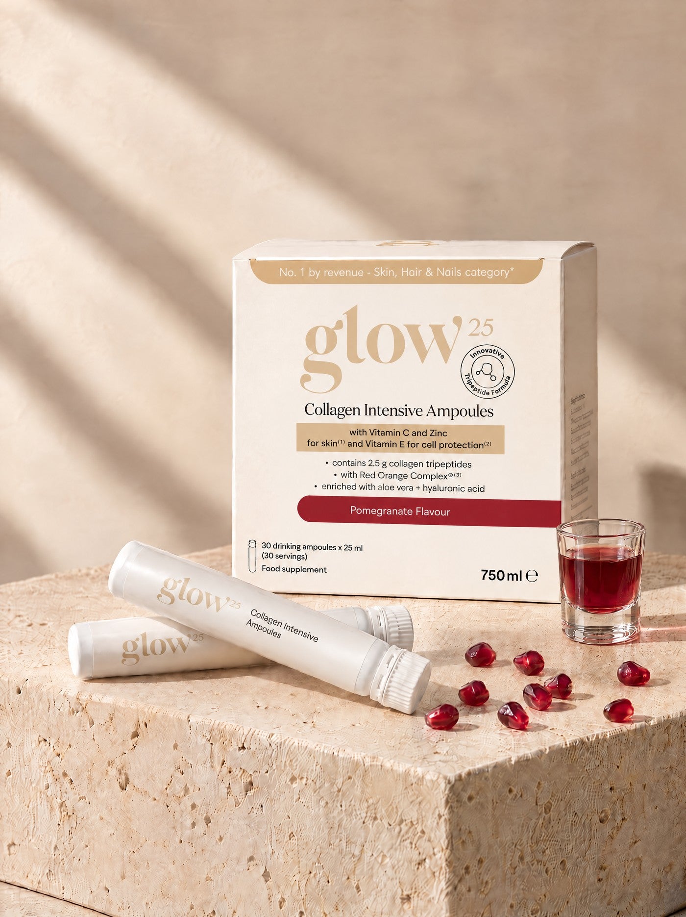 Die Collagène Intensif Ampoules Box mit zwei Ampullen, Granatapfelkernen und einem Glas mit dem roten Shot