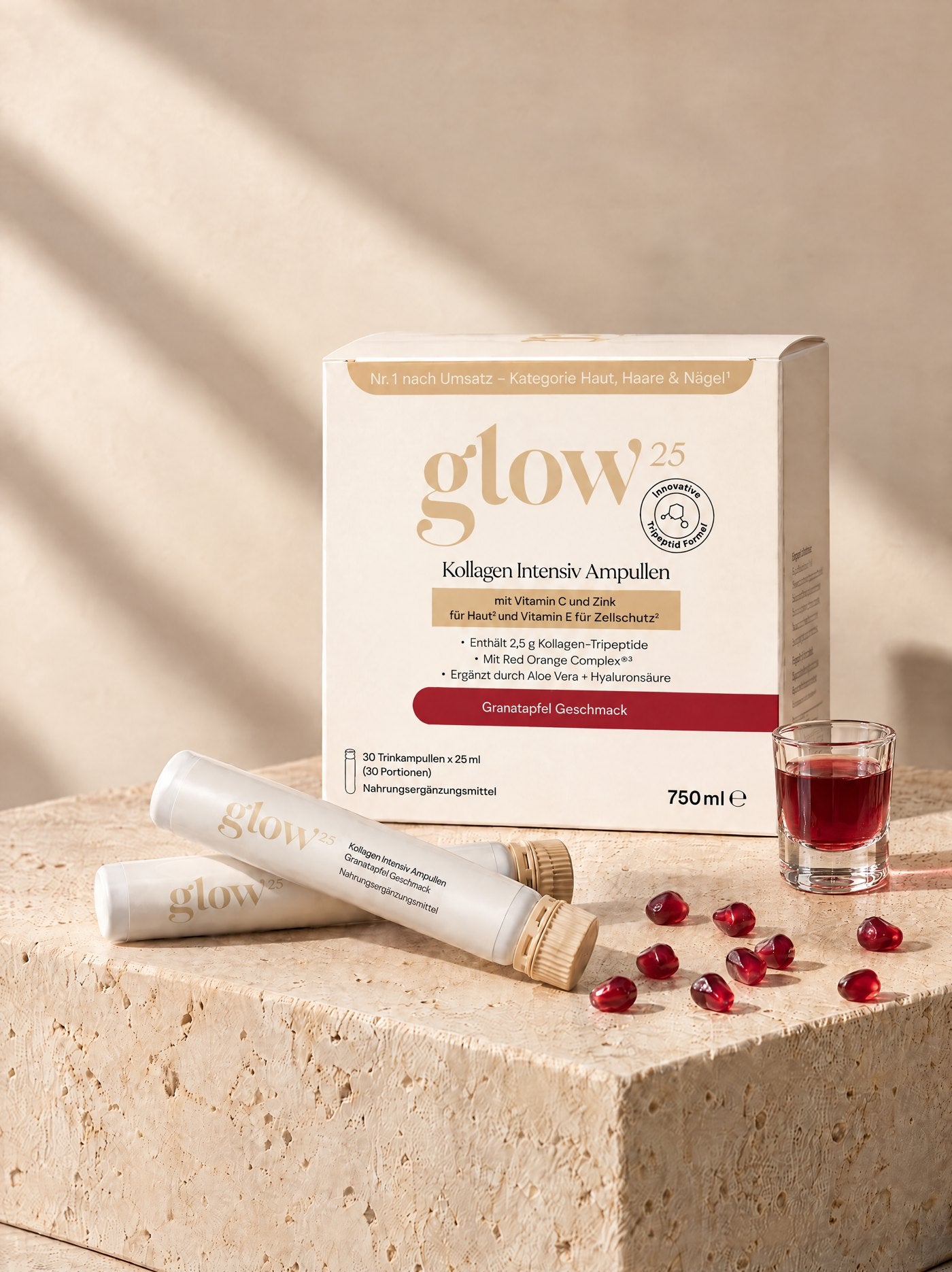 Die Kollagen Intensiv Ampullen Box mit zwei Ampullen, Granatapfelkernen und einem Glas mit dem roten Shot